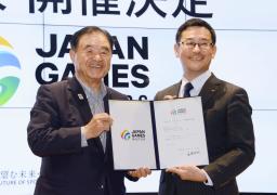 日本スポーツ協会の遠藤利明会長(左)から日本スポーツマスターズの2027年大会の開催決定書を受け取った静岡県の平木省副知事=4日、東京都新宿区