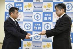 資源エネルギー庁幹部から北海道電力泊原発3号機の再稼働に関する文書を受け取る北海道泊村の高橋鉄徳村長(左)=4日午前、泊村役場