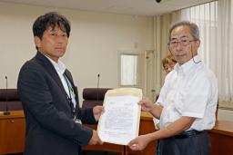 福島県知事宛ての要望書を担当者に提出する、東電福島第1原発事故の集団訴訟で原告団長を務める中島孝さん(右)=5日午前、福島市