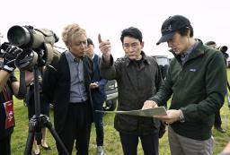 説明を聞きながら釧路湿原周辺にある大規模太陽光発電所の建設予定地を視察するアルピニストの野口健さん(中央)=2日午前、北海道釧路市