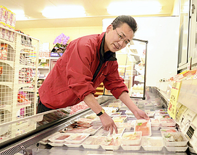 店内の商品を整理する松本さん。仮設住宅の台所として、町民の暮らしを支えている