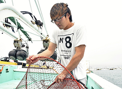 網を手に「少しでも長く漁に出たい」と語る高橋さん