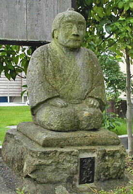 軒の栗庭園に立つ相楽等躬の石像。庭園内には芭蕉と曽良の石像も立つ＝須賀川市大町