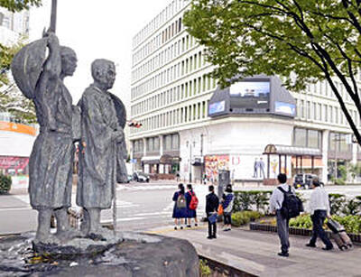 ＪＲ福島駅東口前の交差点手前に立つ芭蕉と曽良の像。行き交う人波をそっと見守っているようだ