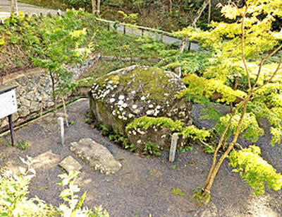 文知摺観音堂のそばにある文知摺石。現在、柵は取り除かれ、周囲の石組みが明治時代に地面から掘り出された史実を伝えている