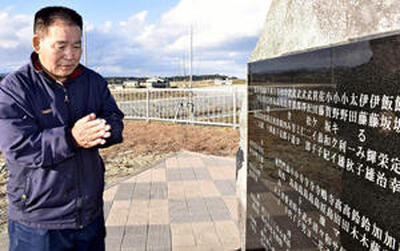 父利雄さん、母キクイさんの名前が刻まれた碑に手を合わせる小野さん＝新地町