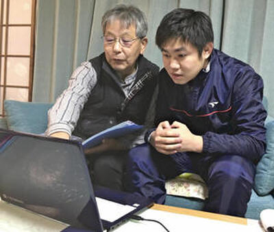 撮影に向けて富士山周辺などの気象情報を調べる斎藤さん（左）と記者