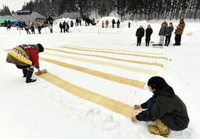 雪まつりで披露されるからむし織反物を漂白する伝統技術「雪ざらし」＝２０１７年２月２６日