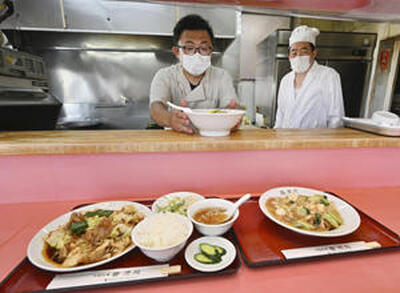 厨房で鍋を振る店主の渡辺平二さん（右）、祐也さんの２人。手作りにこだわり、変わらぬ味を提供し続けている