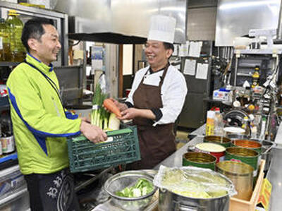 荒川さん（右）は地元産食材を提供してくれる矢吹さんと情報交換しながら、料理作りに励む（吉田義広撮影）