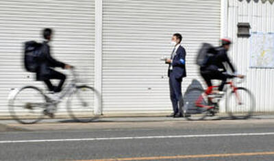 福島市の県道で調査を行う記者。ヘルメットを着用していたのは数えるほどだった