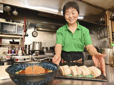 台所でボリュームのある料理を盛りつける千鶴さん（永山能久撮影）