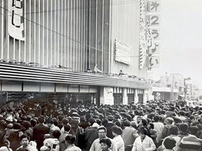 １９６８年１０月、第２うすい増築落成大売り出しの様子。通りに人があふれ、店頭ではブラスバンドの演奏が行われている（うすい百貨店提供）