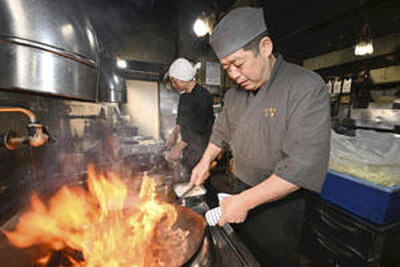 調理場で鍋を振る勝江さん（手前）と裕昌さん。５０年続く伝統の味はこれからも受け継がれていく（石井裕貴撮影）