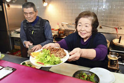 「多くの人が楽しく集える場所にしたい」と笑顔で料理を提供する水野美夫さん、ヒロ子さん夫妻（吉田義広撮影）