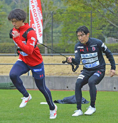 秋本コーチと走りのフォームを確認する山下（左）＝鹿児島県立サッカー・ラグビー場