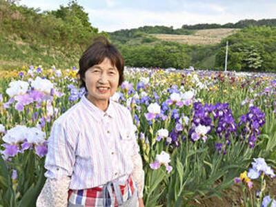 花に囲まれながら「花は生きがい」とほほ笑む渡辺さん＝川俣町山木屋地区