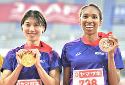 女子４００メートルで優勝し、表彰台で笑顔を見せる松本奈菜子（左）と井戸アビゲイル風果（東邦銀行）