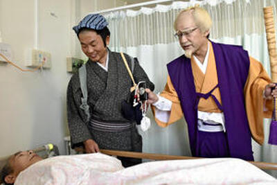 水戸黄門の姿で入院患者を見舞う内田市長（右）。中央は新村院長