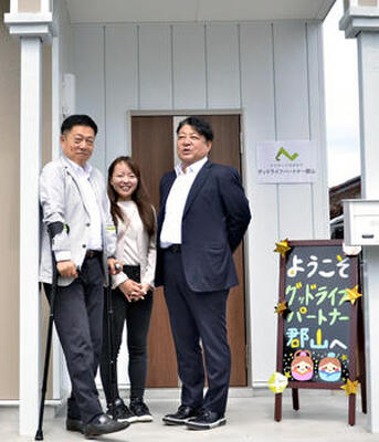 事業所の前に立つ（左から）両角取締役、岡田社長、丹羽会長