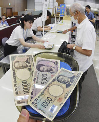 お目見えした新紙幣。銀行には両替を求める市民らが訪れた＝３日午前、福島市・東邦銀行本店営業部