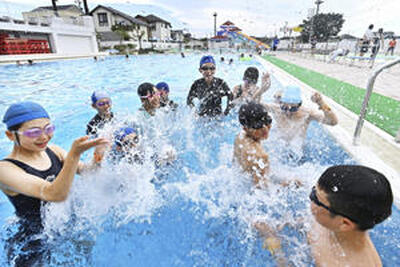 オープン初日のプールで水しぶきを上げる子どもたち＝６日午前、福島中央市民プール