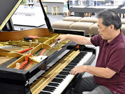能登半島復興支援コンサートに向けて「奇跡のピアノ」の調律を進める遠藤さん＝１２日午後、いわき市