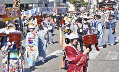 行器を持ち、花嫁衣装の女性らが練り歩いた七行器行列＝２３日午前、南会津町田島