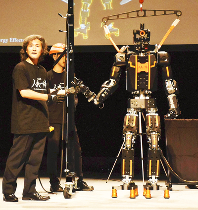 世界初の技術を使った二足歩行型の人型ロボット試作機を紹介する金岡社長（左）ら＝滋賀県