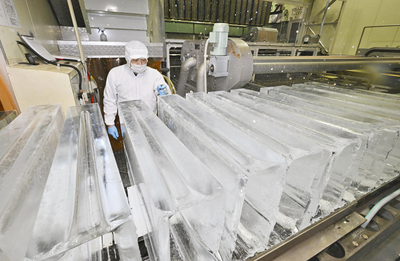 製氷機から出てきた透き通った氷。工場ではフル稼働が続いている＝磐梯町・クールテックサガワ磐梯山製氷工場