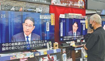 岸田首相の自民党総裁選不出馬を伝えるニュースに見入る来店客＝１４日午後０時２５分ごろ、福島市・ケーズデンキ福島南本店