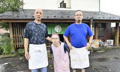 店の前に立つ（左から）保田信次さん、妻英子さん、長男大輔さん。約５０年にわたり創業当時の味を守り続けている（永山能久撮影）