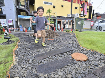 廃材の枕木などで緑化整備されたシカク広場を走る子どもたち＝福島市・旧市民ギャラリー跡地