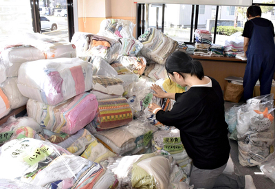 寄せられたタオルを仕分ける住民＝いわき市・平窪公民館