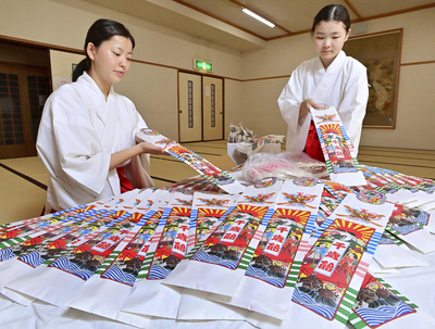 手作業で一つ一つ丁寧に袋詰めされる千歳飴＝郡山市・開成山大神宮