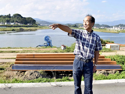 東日本台風の際に決壊した堤防の上に立つ江尻さん。「もう地域から犠牲者を出したくない」と言葉に力を込める＝いわき市平下平窪