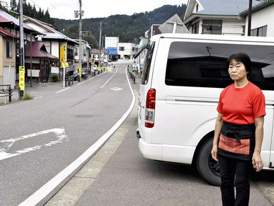 人通りが少ない町並みを見つめる長谷川さん。若者が定住しやすい環境整備を求めている