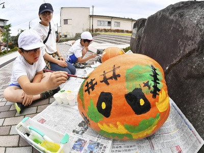 ジャンボカボチャに絵付けする親子ら＝二本松市岳温泉