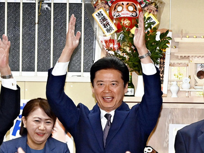 選挙事務所で万歳する玄葉光一郎氏と妻美樹子さん（左）＝２７日午後８時１３分、郡山市