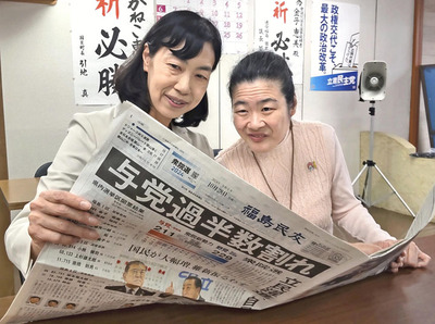 結果を報じる新聞に見入る金子さん（左）と妹美智さん