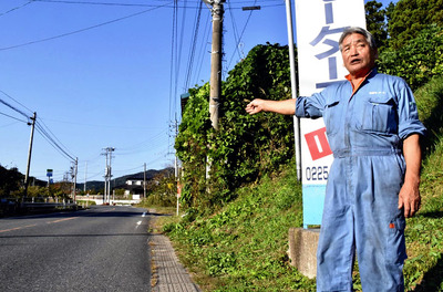 避難道路の県道を前に「原発が爆発しても逃げられないのではないか」と不安を語る大沢さん。がれきや陥没で通行不能となる可能性が高い