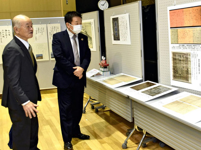 主催した「猪苗代兼載と小平潟天満宮」展で展示品を解説する私（左）。偉人の研究成果を観光や地域の振興につなげたい＝２０２３年１０月、猪苗代町図書歴史情報館