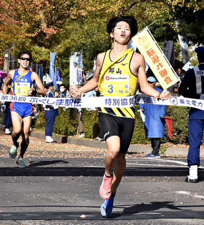 ２年ぶり８度目の優勝を果たした郡山市のアンカー橋本健市。後方はいわき市の村上＝県庁前