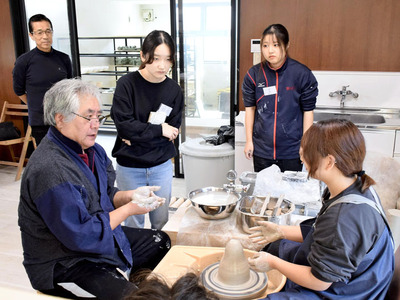 近藤さん（後方左）や根本さん（手前左）から技術指導を受ける学生＝浪江町・陶吉郎窯