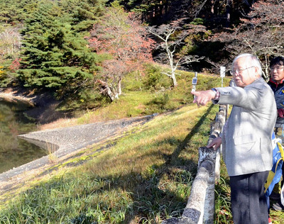 シンポジウムに先立ち行われた半田銀山跡の見学会で、半田沼からの展望に見入る安彦さん