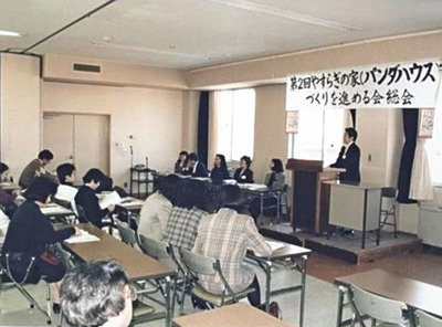 「やすらぎの家（パンダハウス）づくりを進める会」の総会の様子。堀越さん（壇上右から２人目）が私にパンダハウスに携わるきっかけをくれた