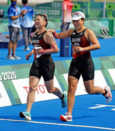 パラリンピック競技でゴールする円尾敦子選手（左）と、ガイドを務めた私。この場に立つまで、多くの出来事を経験した（共同）