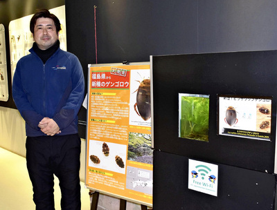 新種ゲンゴロウの紹介コーナーと私。コーナーには生体と標本が展示されている
