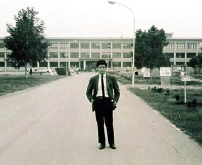 帯広畜産大のキャンパスを背に立つ私。酪農の勉強や実習に明け暮れ、貧乏だったが、楽しい学生生活を送った