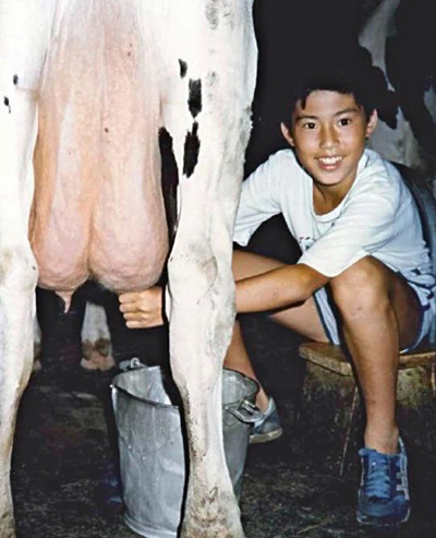 「子どもの家」で初めての乳搾りに挑戦する体験者。施設での生の体験は子どもたちの将来にとって、なんらかの形でプラスになったはずだ